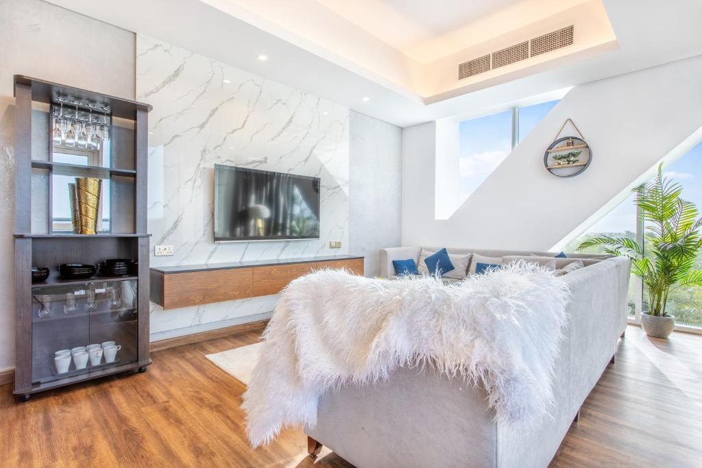 a living room with a couch and a tv at RAKvista Residence in Ras al Khaimah