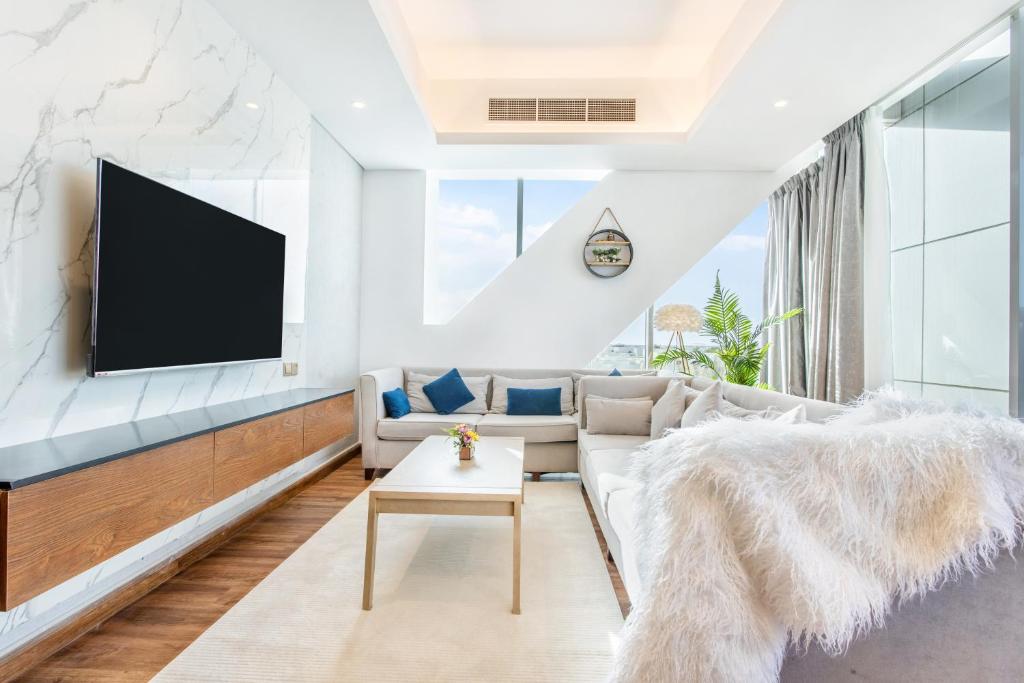 a living room with a couch and a tv at RAKvista Residence in Ras al Khaimah
