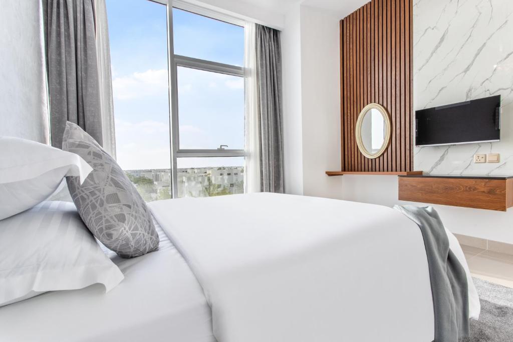 a bedroom with a white bed and a window at RAKvista Residence in Ras al Khaimah