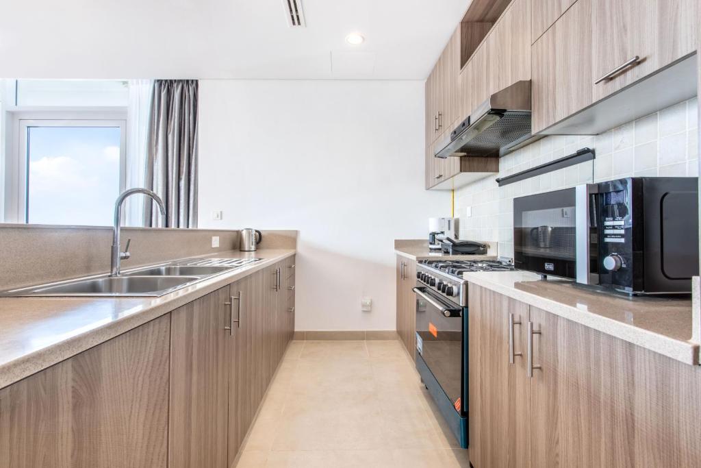 a kitchen with a sink and a microwave at RAKvista Residence in Ras al Khaimah