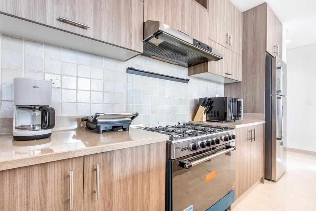 a kitchen with wooden cabinets and a stove at RAKvista Residence in Ras al Khaimah