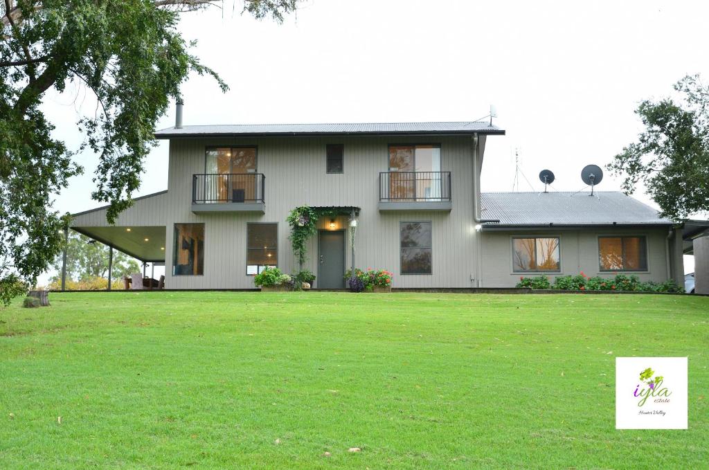 a house with a green lawn in front of it at iyla Estate in Pokolbin