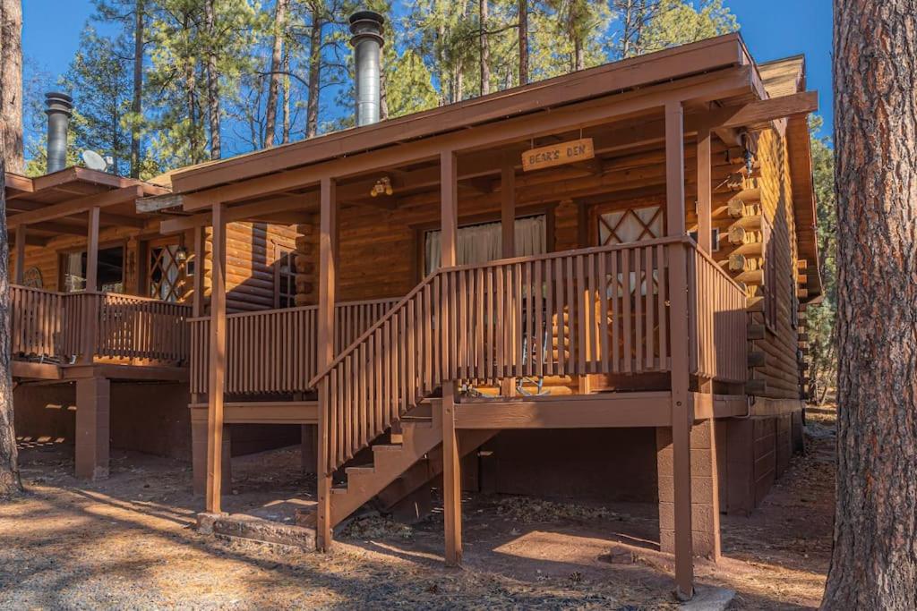 une cabane en rondins dans les bois avec une grande terrasse dans l'établissement Forest Cabin 3 Bear's Den, à Payson