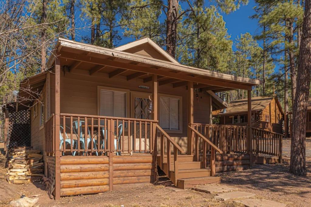 a log cabin with a porch and stairs in the woods at Hideaway forest cabin 9 Squirrels Den in Payson