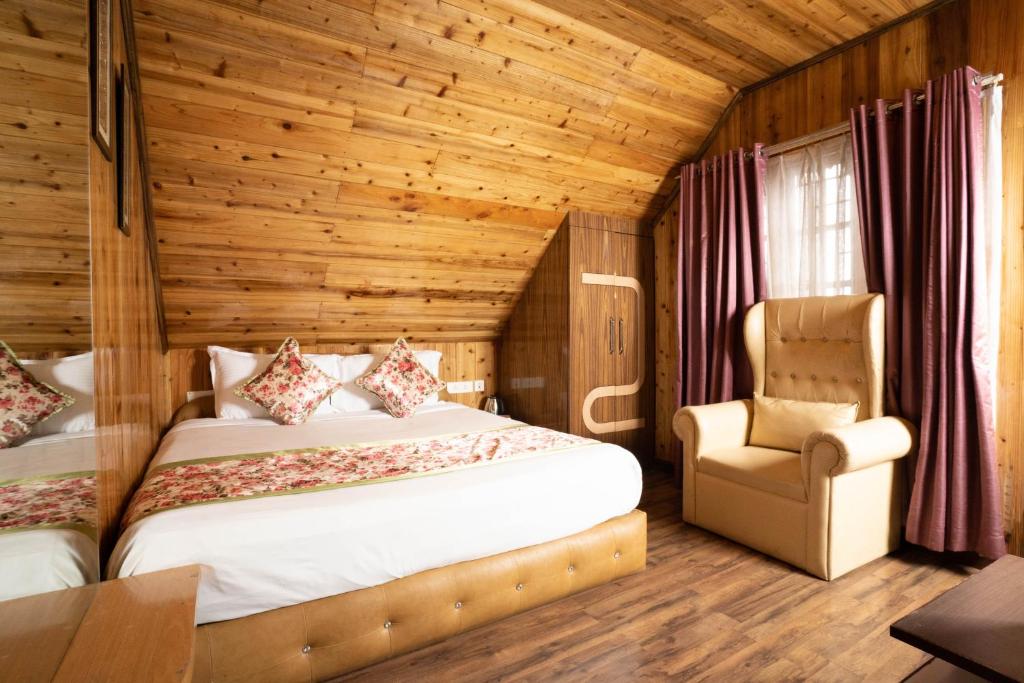 una camera con letto e sedia di Zambala Retreat & Spa Darjeeling a Darjeeling