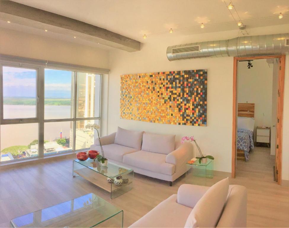 a living room with a couch and a painting on the wall at Luxury Apartment Heart Of Guayaquil in Guayaquil