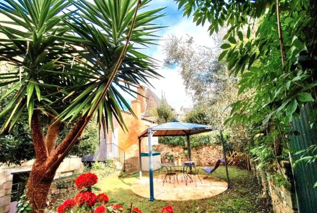 ogród ze stołem i parasolem w obiekcie Le Patio, coeur de ville avec garage et jardin w mieście Vannes