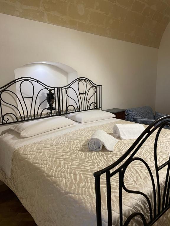 una camera da letto con un grande letto con struttura nera di Dimora La Gravina a Matera