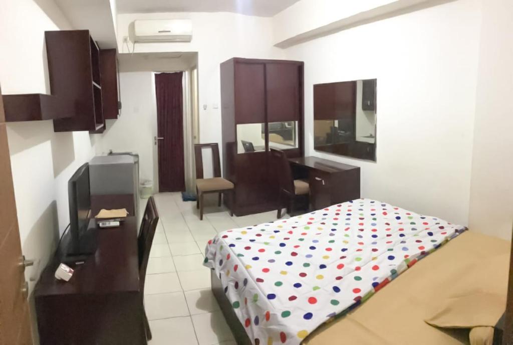 una camera con letto e scrivania di Apartemen margonda residence2 a Pondoktjina 1