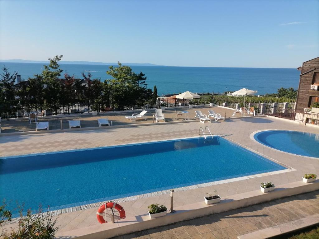 a large swimming pool with a view of the ocean at Apolon 2 in Sozopol