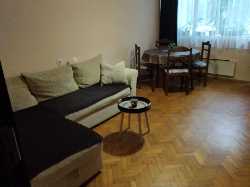 a living room with a couch and a table at Прекрасен апартамент в Бургас in Burgas