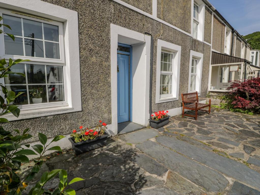 a house with a blue door and a bench at 6 Glyn Terrace in Porthmadog