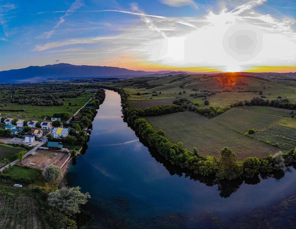 an aerial view of a river with the sun setting at Apartments River Una 4 in Bihać