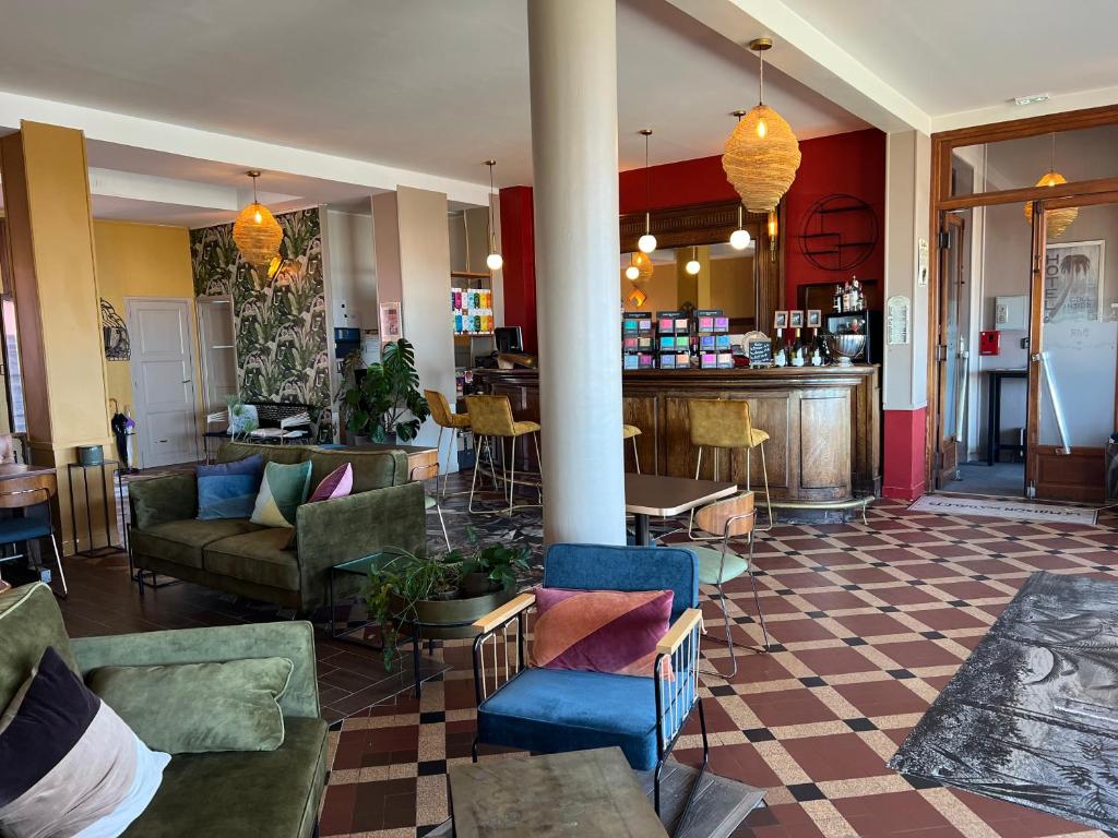 una hall con divani e sedie e un bar di La Maison Des Galets sur le front de mer a Saint-Valéry-en-Caux