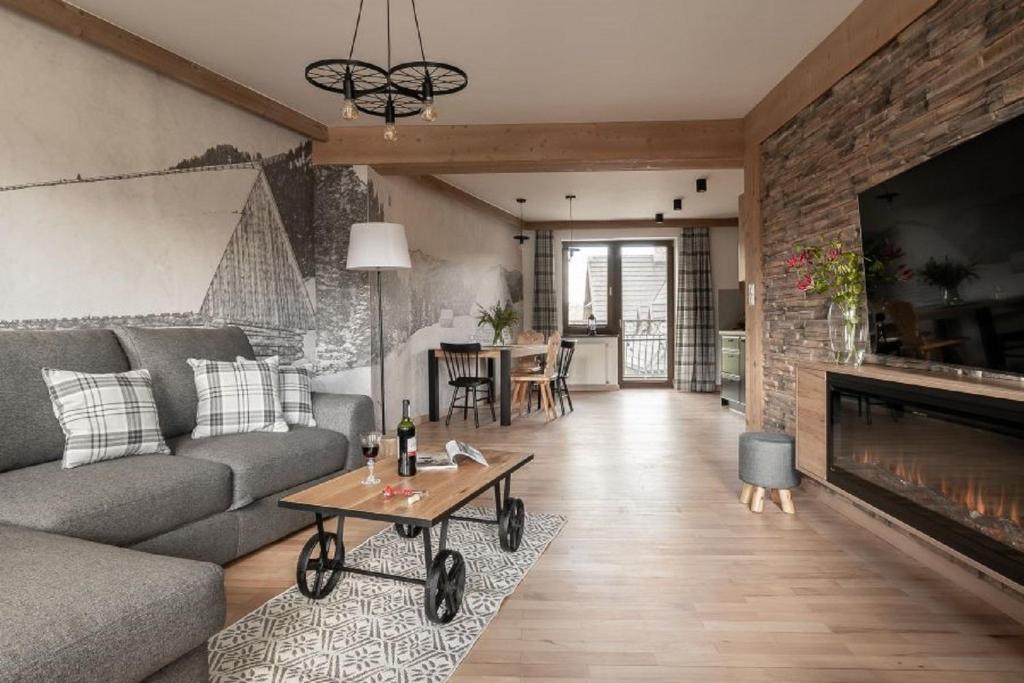 - un salon avec un canapé et une cheminée dans l'établissement Apart-Center Motola Residence, à Zakopane