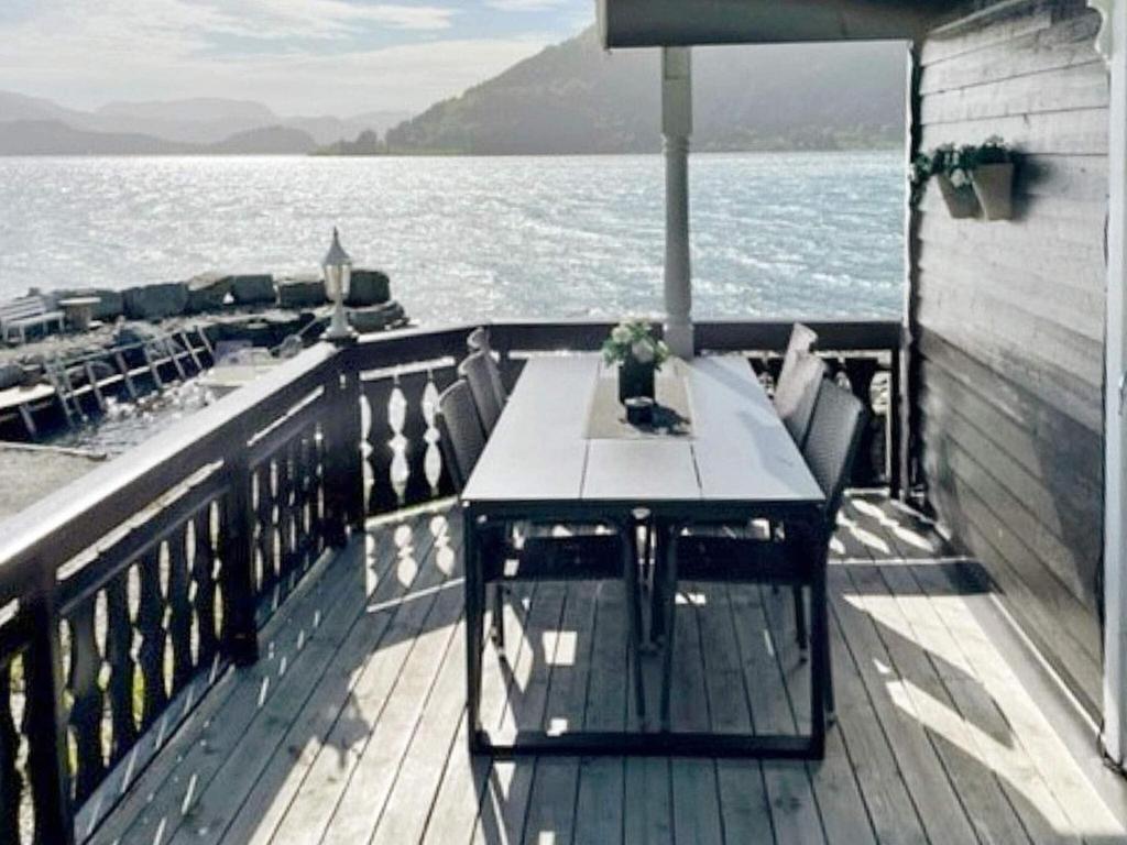 uma mesa no convés de um barco na água em Three-Bedroom Holiday home in Selje 1 em Selje