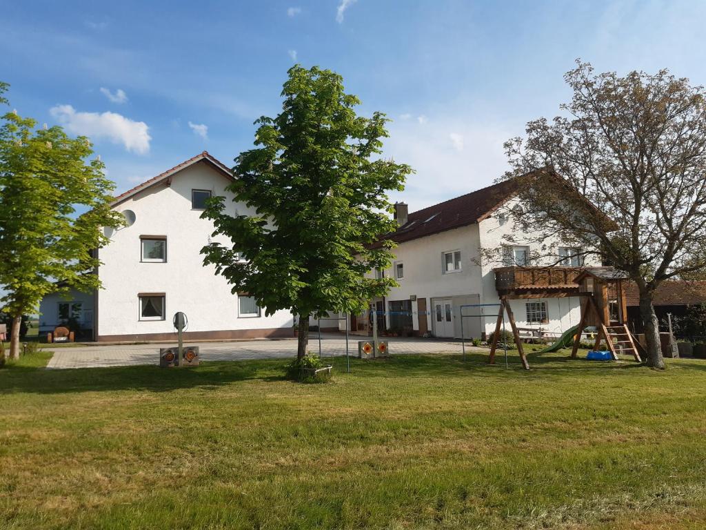een huis met een boom en een speeltuin bij Landhaus-Stockinger in Büchlberg