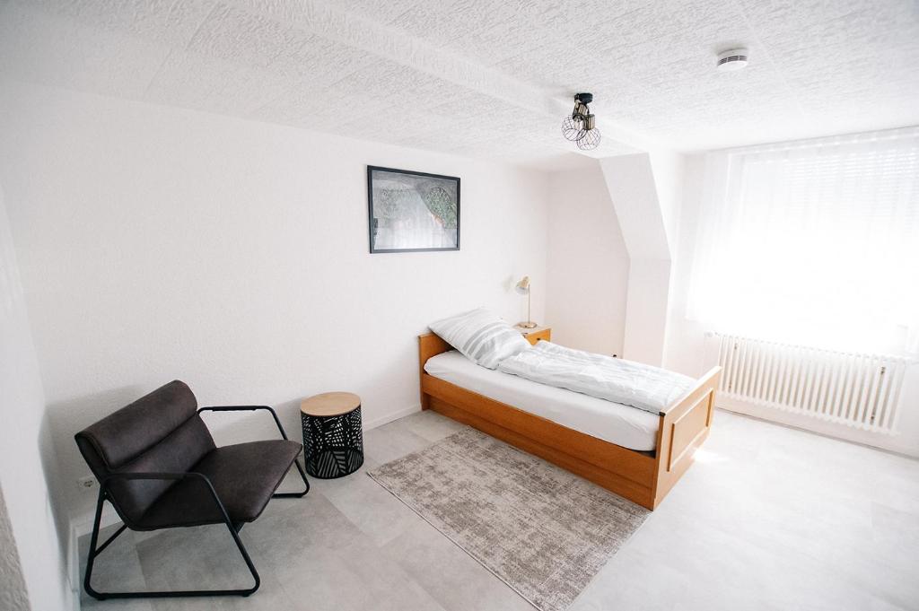 - une chambre avec un lit et une chaise dans l'établissement Gasthof Löwen, à Frickenhausen