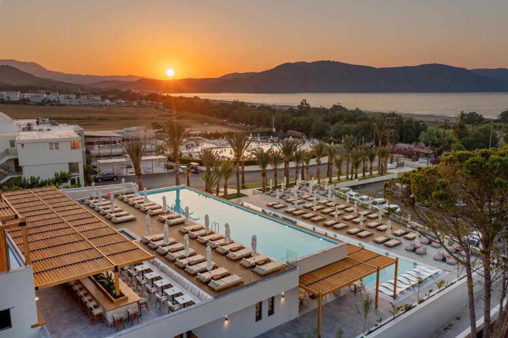 an aerial view of a resort with a pool and a sunset at Georgioupolis Suites in Georgioupolis