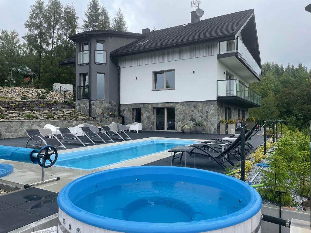 a house with a swimming pool in front of a house at Apartamenty 'Okno z widokiem' in Wisła