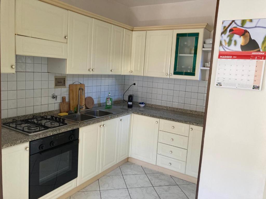 uma cozinha com armários brancos e um forno com placa de fogão em Casa di Abe em Florença