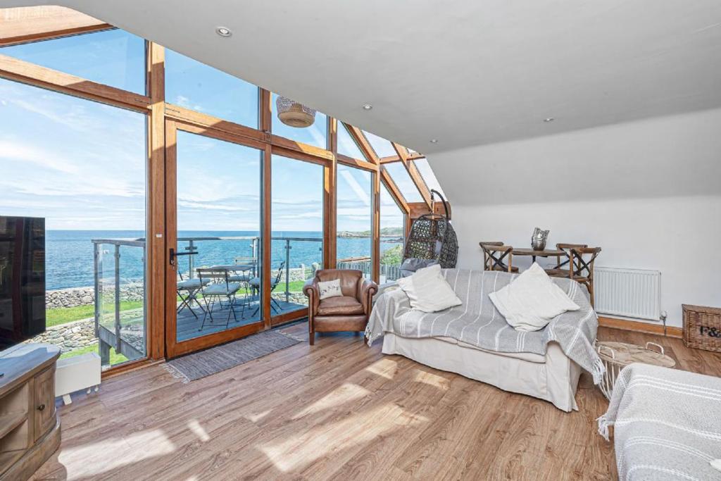 a bedroom with a bed and a view of the ocean at Gorwel Manaw in Cemaes Bay