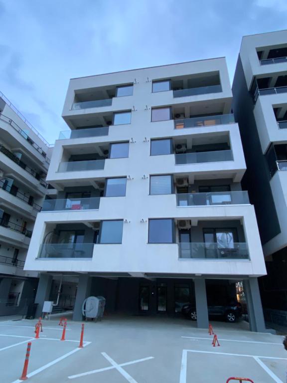 an apartment building with a parking lot in front at Ela's Apartment in Mamaia Sat/Năvodari