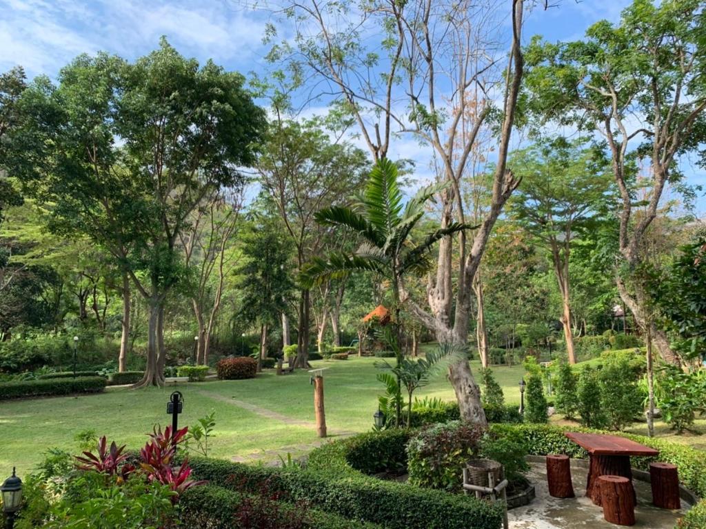 un parque con árboles y un campo verde en Moosiyard Hometel Khaoyai en Mu Si