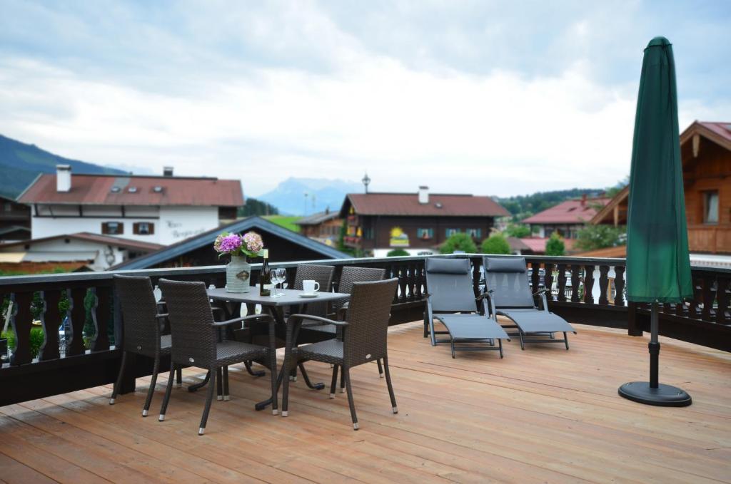 patio con mesa y sillas en el balcón en Kaisereck, en Reit im Winkl