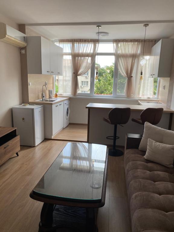 uma cozinha e sala de estar com um sofá e uma mesa em Rose em Karlovo