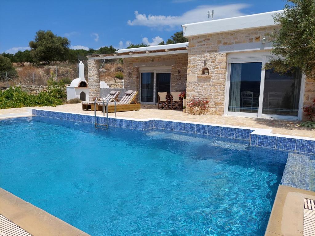 a swimming pool in front of a house at Villa Petra in Kamilari