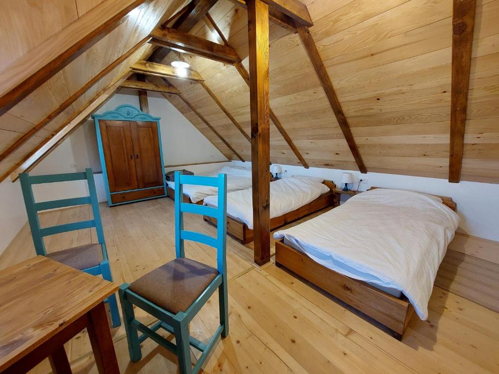 a bedroom with two beds and a desk and a ladder at KUĆA ZA ODMOR MALI DVORI in Začretje