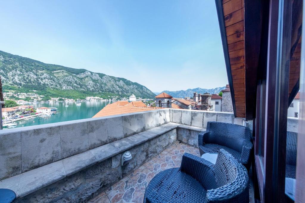 a balcony with two chairs and a view of the water at Vincenza Apartment in Kotor