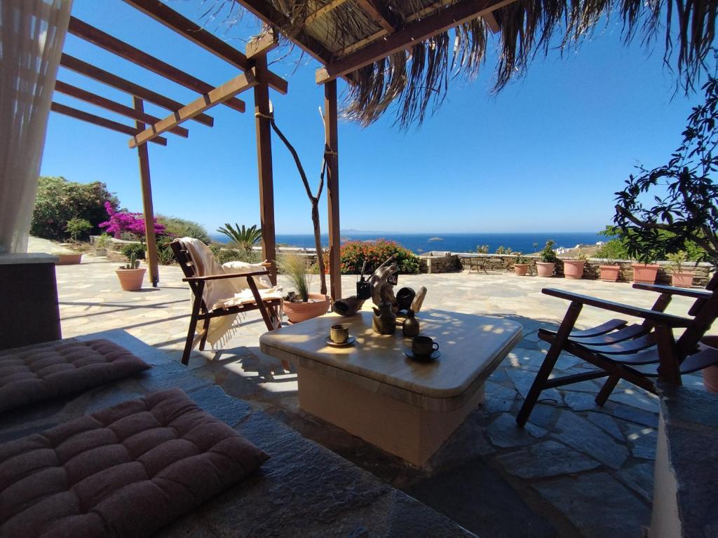 eine Terrasse mit einem Tisch, Stühlen und Meerblick in der Unterkunft PAPs Farm - Alexandria Double Apartment in Gavrio
