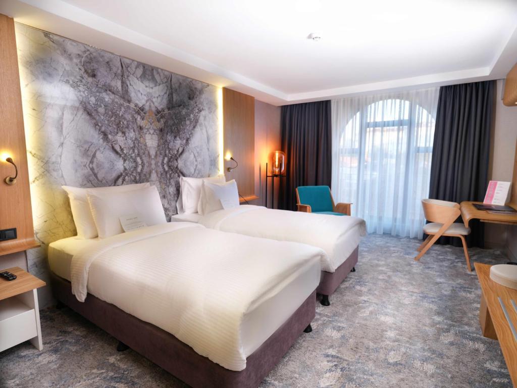 سرير أو أسرّة في غرفة في Grande Arte Hotel