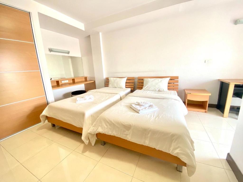 a hotel room with two beds and a bathroom at Rangsit Apartment II in Ban Talat Rangsit