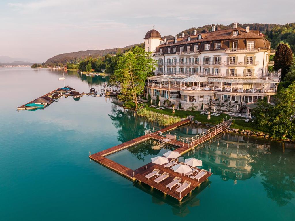 an aerial view of a hotel on the water at Hotel Schloss Seefels in Pörtschach am Wörthersee
