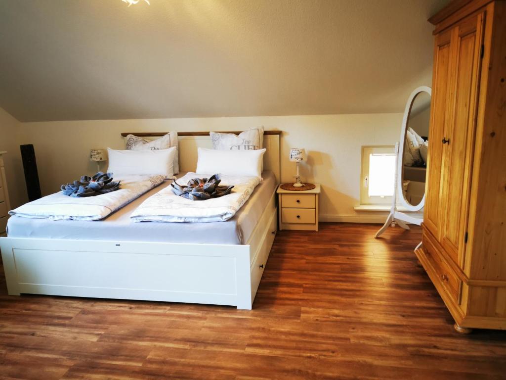 a bedroom with a large white bed with a mirror at Sommerhaus Seidel - mit kostenlosem Parkplatz - in Stralsund