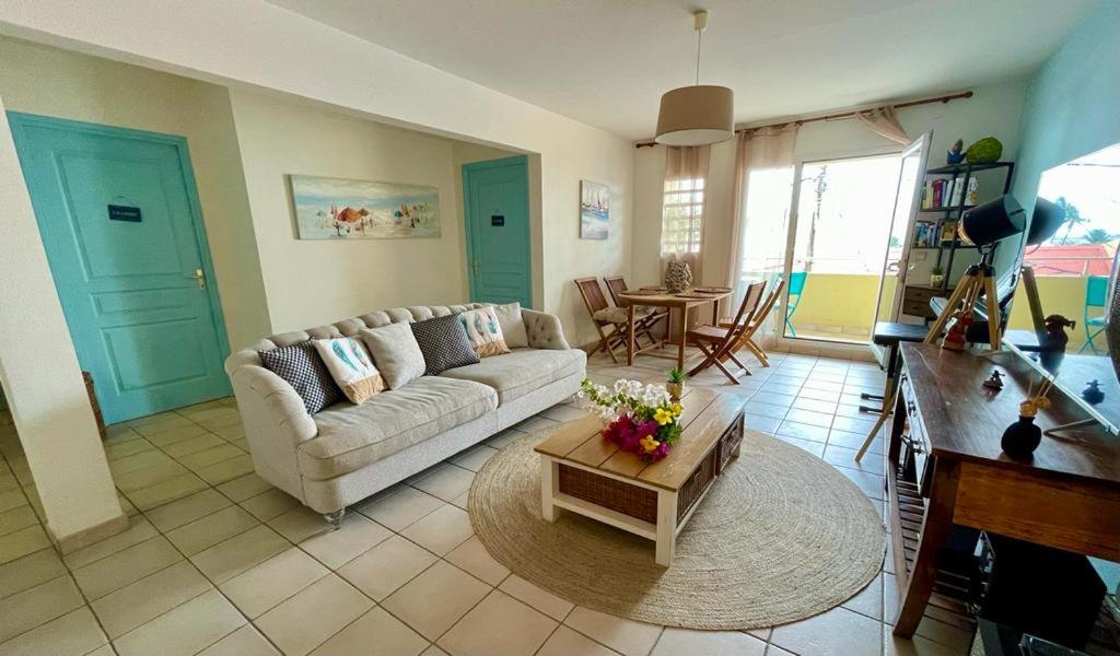 a living room with a couch and a table at LA PLAYA - L'Appartement COZY - 2 à 5 personnes in Sainte-Anne