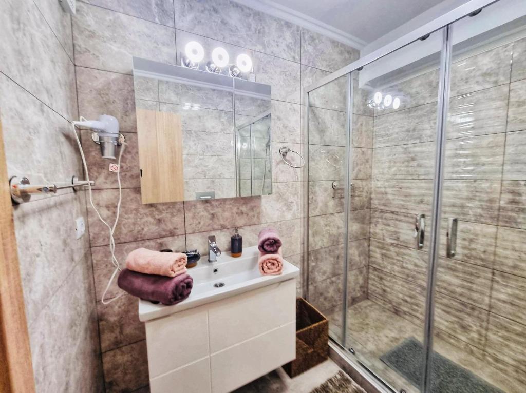 een badkamer met een douche en een wastafel bij Deluxe Lake View in Mamaia