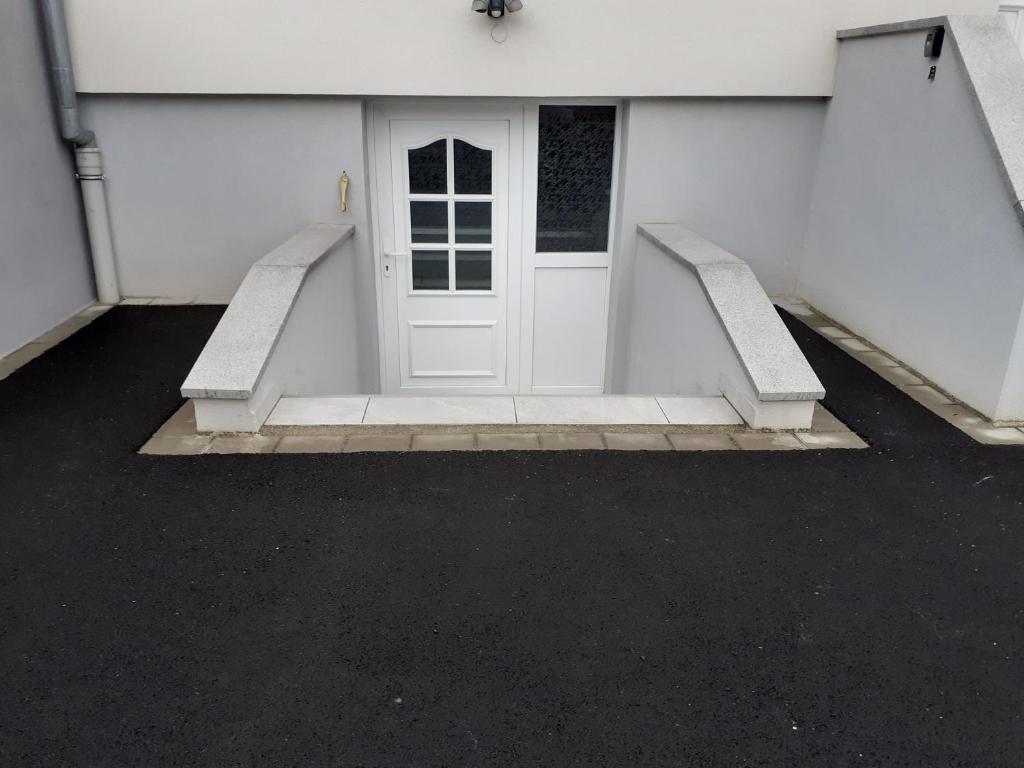Una puerta blanca en un edificio blanco con escaleras. en f 2 atypique 50 m/2, en Houssen