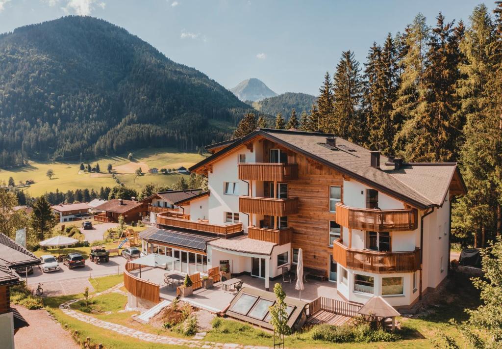 een luchtzicht op een resort met bergen op de achtergrond bij Glüxplatzl Appartements am Wald in Sankt Martin am Tennengebirge