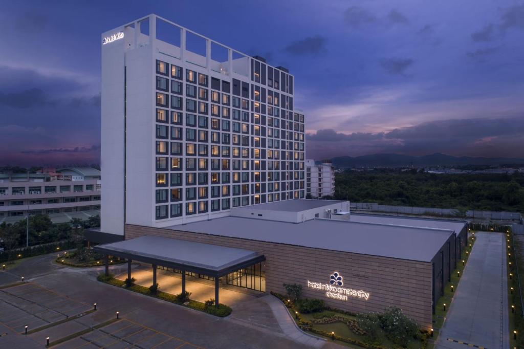a large building with a lit up sign on it at Hotel Nikko Amata City Chonburi in Chon Buri