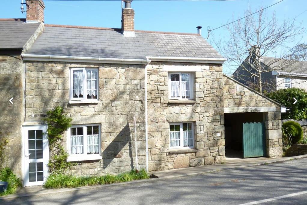 ein altes Steinhaus mit Garage in der Unterkunft Lovely Cornish cottage in small village setting in Saint Hilary