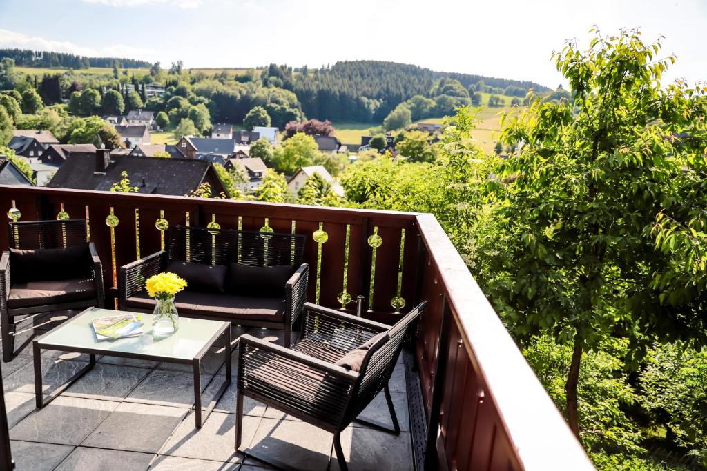 a balcony with chairs and a table with a view at Sonnen Panorama - Abenteurer und Weltentdecker in Winterberg