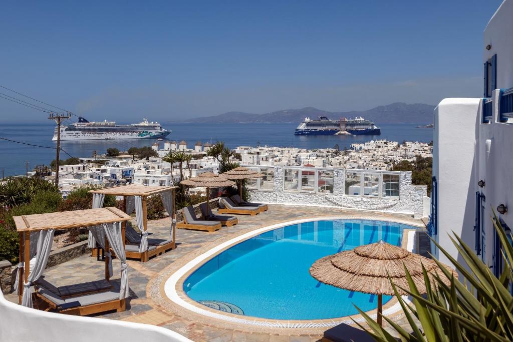 una piscina con sillas y sombrillas en un edificio en Marisso Hotel en Mykonos ciudad