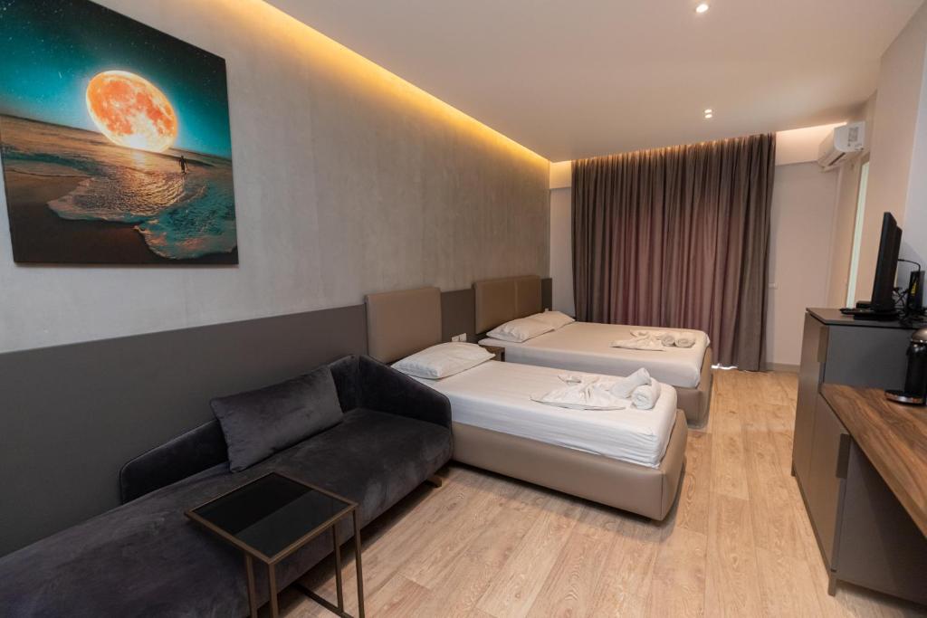 Habitación de hotel con 2 camas y sofá en NOVUS ROOMS, en Vlorë