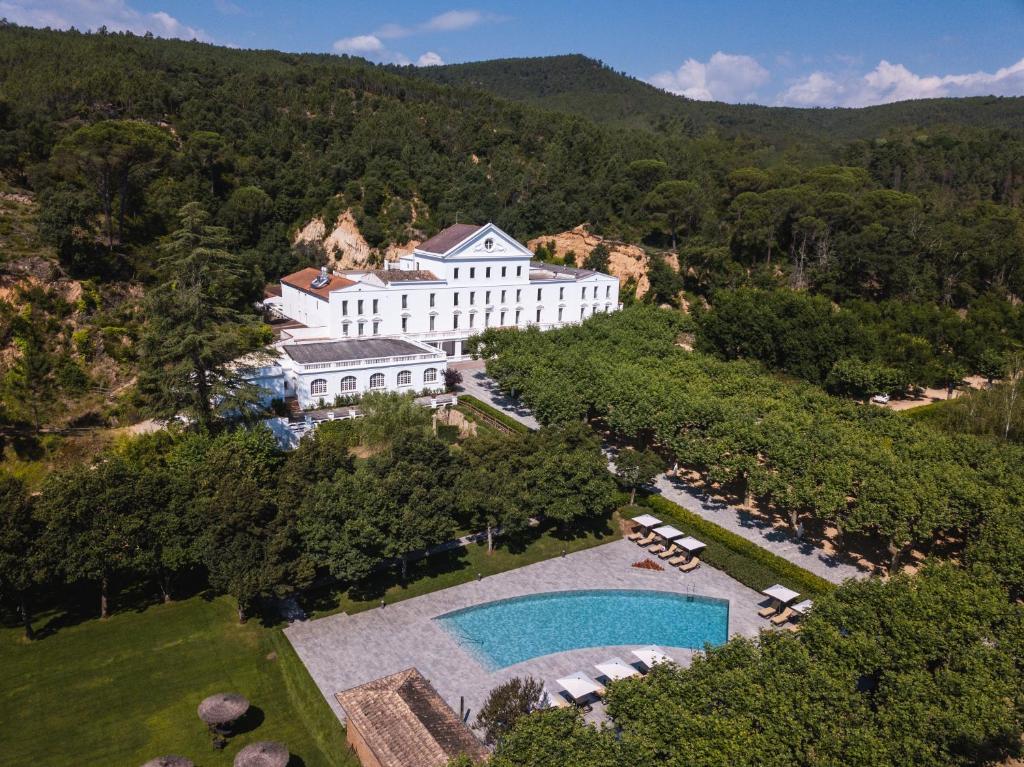 eine Luftansicht auf ein großes weißes Gebäude mit einem Pool in der Unterkunft Hotel Balneari Termes Orion in Santa Coloma de Farners