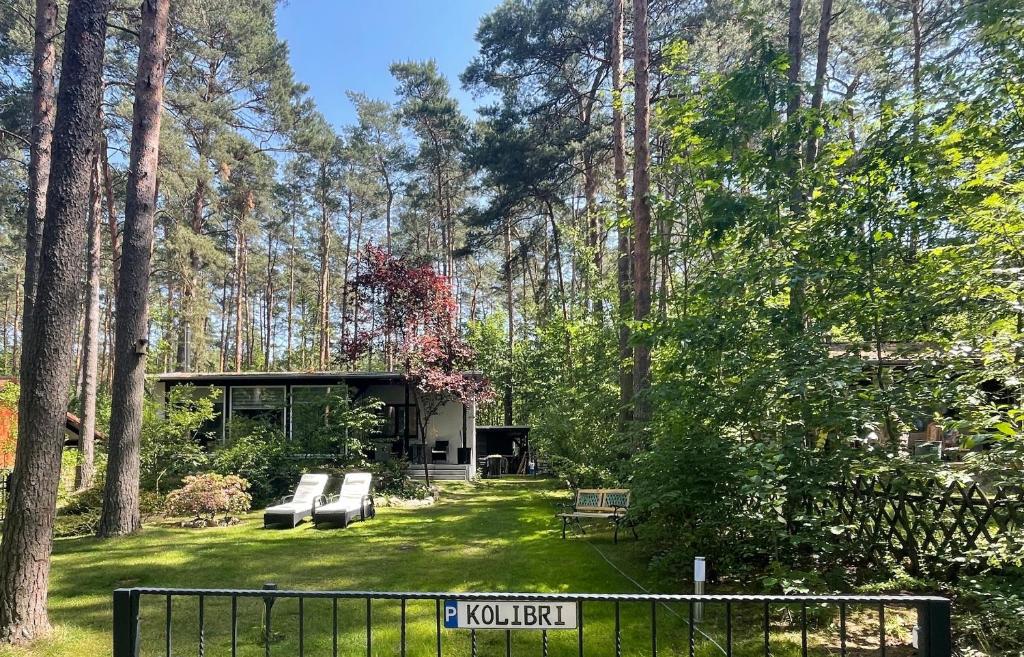 ein Haus inmitten eines Gartens mit Bäumen in der Unterkunft NEUES Ferienhaus "Kolibri" direkt in Wandlitz, in Wandlitz