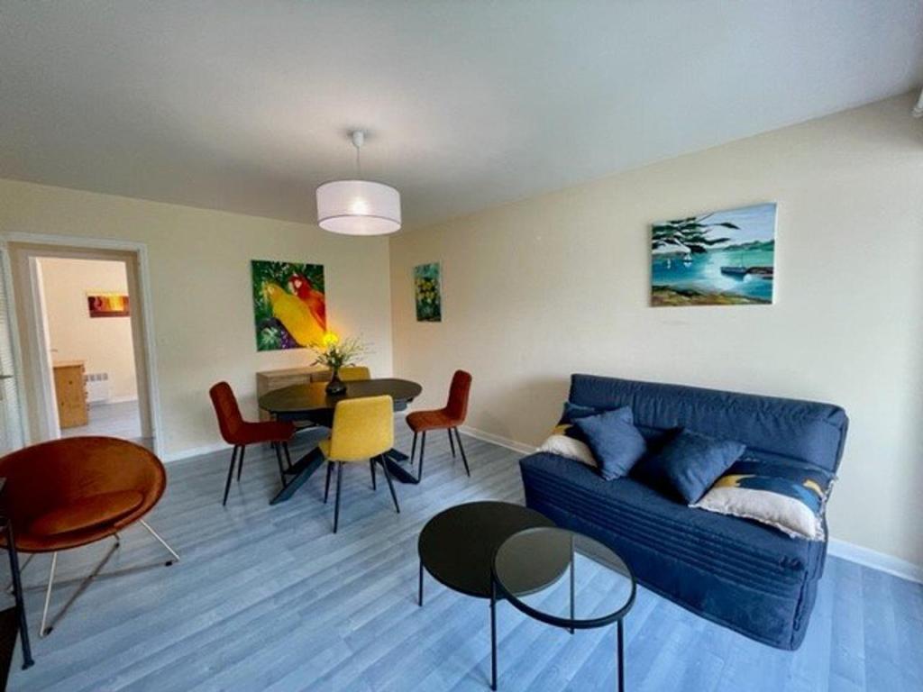 un salon avec un canapé bleu et une table dans l'établissement Quiberon - Appartement T2 - 50m² - Plein centre, proche plage, parking privé, loggia sud - FR-1-478-218, à Quiberon
